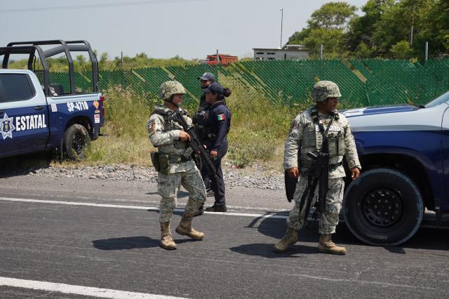 Mexican Army soldiers and a state police officer stand near the scene where the body of Morena federal deputy Zenyazen Escobar was found inside a black Mercedes-Benz on the Veracruz-Xalapa highway near La Gloria, Veracruz state, Mexico, on September 4, 2026. The body of a Mexican federal lawmaker was found with a gunshot wound on a highway in the state of Veracruz, authorities said on September 4. Zenyazen Escobar was found inside his vehicle with a firearm nearby, the state's secretary of government told a press conference, declining to say whether the death was a suicide or the result of an attack. (Photo by Victoria Razo / AFP)
