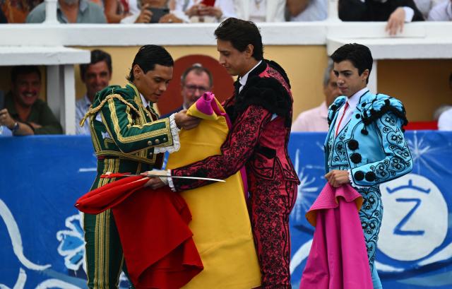 (LtoR) Peruvian matador Pedro Luis receives his alternativa from Peruvian matador Andres Roca Rey and Spanish matador Marco Perez during a bullfight at the Marcel-Dangou arena in Bayonne, southwestern France, on September 4, 2026. (Photo by Gaizka IROZ / AFP)