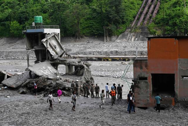 Security and relief personnel stand along the Trishuli riverbank in the aftermath of flash floods at Trishuli Bazar in Nepal's Nuwakot district on September 5, 2026. Devastating floods on the China-Nepal border have killed at least 1,287 people in Nepal, the disaster authority said September 4, with the number of missing at 5,083. (Photo by Prakash MATHEMA / AFP)