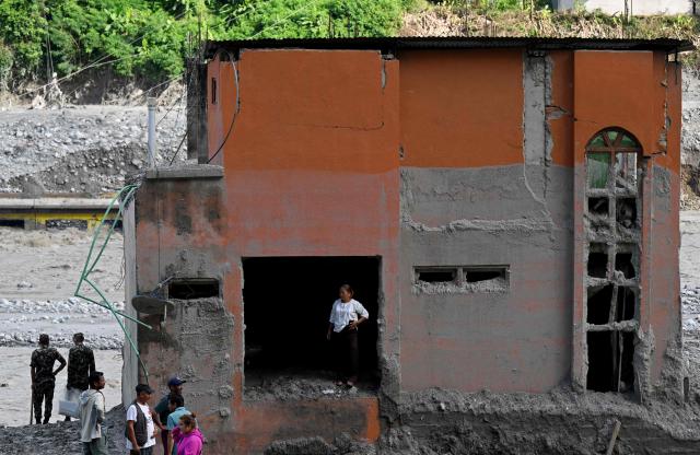 A flash flood survivor looks out from inside a sludge-ridden house at Trishuli Bazar in Nepal's Nuwakot district on September 5, 2026. Devastating floods on the China-Nepal border have killed at least 1,287 people in Nepal, the disaster authority said September 4, with the number of missing at 5,083. (Photo by Prakash MATHEMA / AFP)