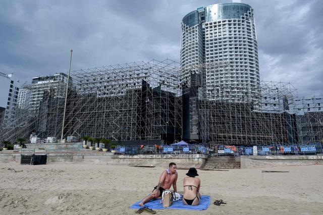 A couple sit on a beach behind the stage for the 2026 Miss World pageant in Nha Trang, Vietnam's Khanh Hoa province on September 5, 2026. (Photo by Nhac NGUYEN / AFP)