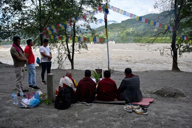 Lok Bahadur Sherpa (L), with monks performs the funeral rites of his son and flash flood victim Gymacho Sherpa along the Trishuli riverbank at Trishuli Bazar in Nepal's Nuwakot district on September 5, 2026. Devastating floods on the China-Nepal border have killed at least 1,287 people in Nepal, the disaster authority said September 4, with the number of missing at 5,083. (Photo by Prakash MATHEMA / AFP)