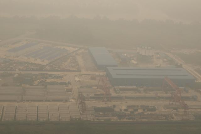This aerial photo taken from a commercial aircraft shows thick haze from Indonesian forest fires obscuring an industrial site in Kuching, the capital city of Malaysia's Sarawak state on the island of Borneo on September 5, 2026. Indonesia has for weeks been fighting wildfires blanketing parts of Borneo and Sumatra with smog, with haze also contributing to air pollution in Malaysia, Singapore, and the Philippines. (Photo by Mohd Rasfan / AFP)