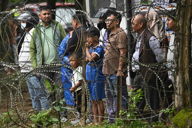 Flash flood survivors stand outside a temporary relief camp at Trishuli Bazar in Nepal's Nuwakot district on September 5, 2026. Devastating floods on the China-Nepal border have killed at least 1,287 people in Nepal, the disaster authority said September 4, with the number of missing at 5,083. (Photo by Pedro Pardo / AFP)