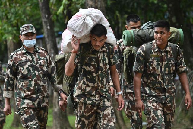 Army personnel carry relief supplies for flash flood victims inside a temporary relief camp at Trishuli Bazar in Nepal's Nuwakot district on September 5, 2026. Devastating floods on the China-Nepal border have killed at least 1,287 people in Nepal, the disaster authority said September 4, with the number of missing at 5,083. (Photo by Pedro Pardo / AFP)