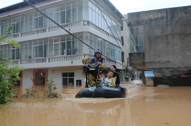 A member of a search and rescue team evacuates people from floods affected area following heavy rains in Suichuan, Central China's Jiangxi province on September 4, 2026. (Photo by CN-STR / AFP) / China OUT