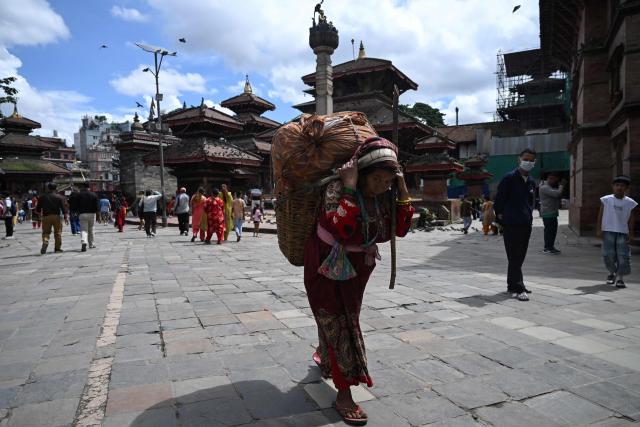 A woman carries a bamboo basket across the Hanuman Dhoka Durbar Square in Kathmandu on September 5, 2026. (Photo by Arun SANKAR / AFP)