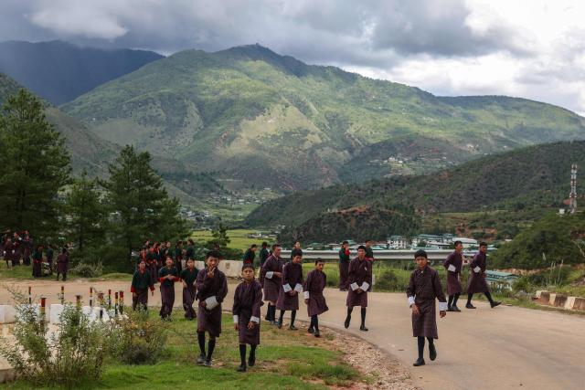 Students look on as they leave after attending their school in Paro, Bhutan on September 4, 2026. (Photo by Niharika KULKARNI / AFP)
