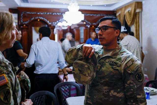 US military personnel stand near the dining table during the visit of the US Ambassador to Israel to the home of an American-Palestinian resident who has previously been attacked twice and faces ongoing harassment from Israeli settlers, in the Israeli-occupied West Bank town of Turmus Ayya, about 23 kilometres (14 miles) north-east of Ramallah, where a large proportion of the town's residents hold dual nationality, on September 5, 2026. Attacks by Israeli settlers on the Palestinian village of Qusra drew unusually strong criticism from the US ambassador on September 3, 2026, while Britain's foreign secretary vowed a tough response to "appalling" violence by Israeli settlers against Palestinians. All Israeli settlements in the West Bank, which has been occupied since 1967, are illegal under international law. (Photo by John Wessels / AFP)