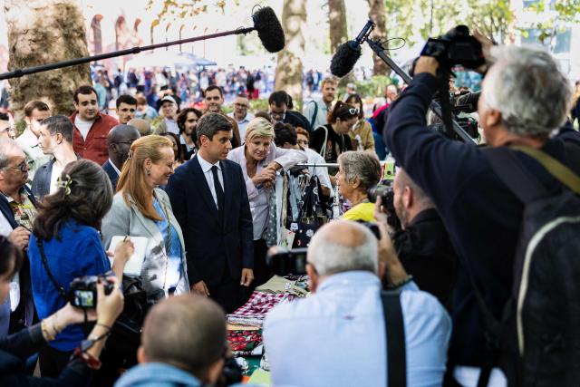 General Secretary of French centrist party Renaissance and 2027 presidential candidate Gabriel Attal (C) and Ensemble pour la Republique MP Violette Spillebout (L), a member of Attal's presidential campaign team, during their visit of the Braderie de Lille flea market in Lille, northern France on September 5, 2026. (Photo by Sameer Al-DOUMY / AFP)