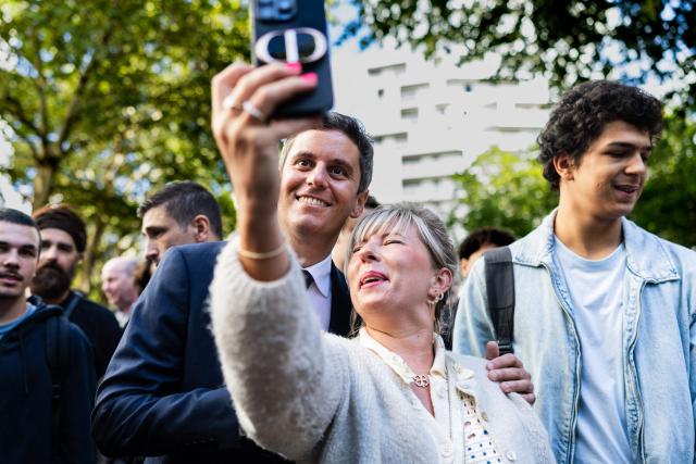 General Secretary of French centrist party Renaissance and 2027 presidential candidate Gabriel Attal (C,L) poses for a selfie with a well-wisher as he visits the Braderie de Lille flea market in Lille, northern France on September 5, 2026. (Photo by Sameer Al-DOUMY / AFP)