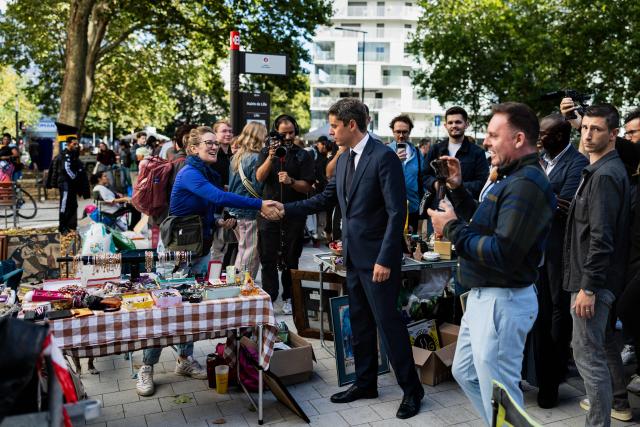 General Secretary of French centrist party Renaissance and 2027 presidential candidate Gabriel Attal (C) shakes hands with a woman as he visits the Braderie de Lille flea market in Lille, northern France on September 5, 2026. (Photo by Sameer Al-DOUMY / AFP)