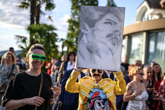 A fan holds a painting of Freddie Mercury during Montreux Freddie Day, marking the 80th anniversary of the birth of the Queen frontman, in Montreux, Switzerland, on September 5, 2026. (Photo by Fabrice COFFRINI / AFP)