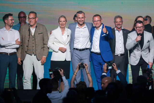 Members of the party leadership including Ulrich Siegmund (C), top candidate in the Saxony-Anhalt state election for the far-right Alternative for Germany (AfD) party, and federal AfD co-leaders Alice Weidel and Tino Chrupalla stand on stage for the national anthems at a campaign event in Magdeburg, eastern Germany, on September 5, 2026, one day before regional elections in the eastern federal state of Saxony-Anhalt. Germany faces a landmark regional election on September 6, 2026 in the ex-communist east where the far-right Alternative for Germany (AfD) party is easily expected to win and has its sights on heading its first state government. While it is far from assured that Alternative for Germany will win enough votes to rule the state alone, topping the polls in Saxony-Anhalt state would heap pressure on Chancellor Friedrich Merz and spell another boost for the anti-immigration party. (Photo by Ronny HARTMANN / AFP)