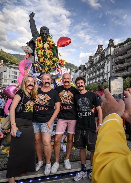 Fans pose in front of Freddie Mercury statue overlooking Lake Geneva during Montreux Freddie Day, marking the 80th anniversary of the birth of British music band Queen's frontman, in Montreux, Switzerland, on September 5, 2026. (Photo by Fabrice COFFRINI / AFP)