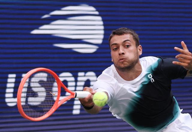Italy's Flavio Cobolli plays a return to Belgium's Alexander Blockx during their men's singles third round tennis match on day seven of the US Open tennis tournament at the USTA Billie Jean King National Tennis Center in New York City on September 5, 2026. (Photo by TIMOTHY A. CLARY / AFP)