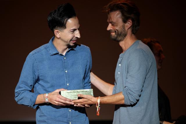 Spanish AFP photographer Luis Tato (L) receives from Jérémy Huffer (R), Editor-in-Chief of Paris Match, the Visa d'Or News Roger Thérond during the 38th edition of the "Visa pour l'image" press photography festival in Perpignan, southwestern France, on September 5, 2026. Tato won the Visa d'Or News prize for news photography for his coverage of the Generation Z protests in Madagascar. His work on the story had already been recognised at the World Press Photo Awards in April. Accepting the award, 37-year-old Tato paid tribute to the founder of the festival Jean-Francois Leroy, who died on Monday. (Photo by Valentine CHAPUIS / AFP)