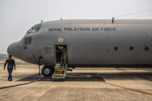 Members of the Royal Malaysian Air Force prepare a C-130 aircraft for a cloud-seeding operations at the air force base in Kuching, the capital of Sarawak state on the island of Borneo, on September 6, 2026. Malaysia launched a three-day cloud-seeding operation on September 3 in a bid to ease hazardous haze choking Sarawak state, as smoke from Indonesian forest fires pushed air quality to dangerous levels. (Photo by Mohd Rasfan / AFP)