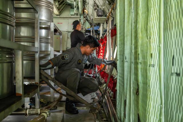 Members of the Royal Malaysian Air Force prepare a C-130 aircraft for a cloud-seeding operations at the air force base in Kuching, the capital of Sarawak state on the island of Borneo, on September 6, 2026. Malaysia launched a three-day cloud-seeding operation on September 3 in a bid to ease hazardous haze choking Sarawak state, as smoke from Indonesian forest fires pushed air quality to dangerous levels. (Photo by Mohd Rasfan / AFP)