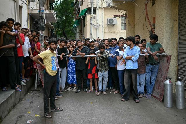 People gather to watch as rescue personnel conduct a search operation at the site following a building collapse in the Satya Niketan area in New Delhi on September 6, 2026. (Photo by Sajjad HUSSAIN / AFP)