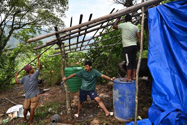 Men build a temporary shelter for livestock in the aftermath of flash floods in Trishuli, in Nepal's Nuwakot district on September 6, 2026. The glacial and mountain collapse on the China-Nepal border killed at least 1,384 people and left more than 5,500 missing across the two countries. (Photo by Pedro PARDO / AFP)
