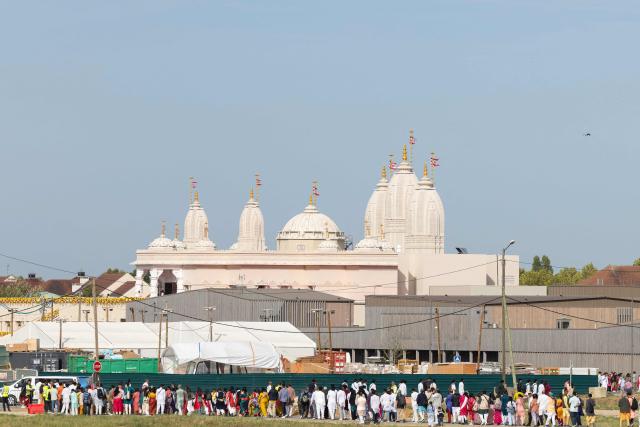 Hindu devotees queue to enter the newly consecrated BAPS (Bochasanwasi Akshar Purushottam Swaminarayan Sanstha) Hindu temple in Bussy-Saint-Georges on September 6, 2026. On September 6, 2026, thousands of Hindus are celebrating the consecration of the first major temple built in France by the BAPS organization, which promotes it as 'an emblem of Indian culture and Hinduism.' Hailed as the largest Hindu temple built in continental Europe in a traditional style, the edifice stands in the new town of Bussy-Saint-Georges (Seine-et-Marne), 30 km east of the capital. (Photo by Kenzo TRIBOUILLARD / AFP)