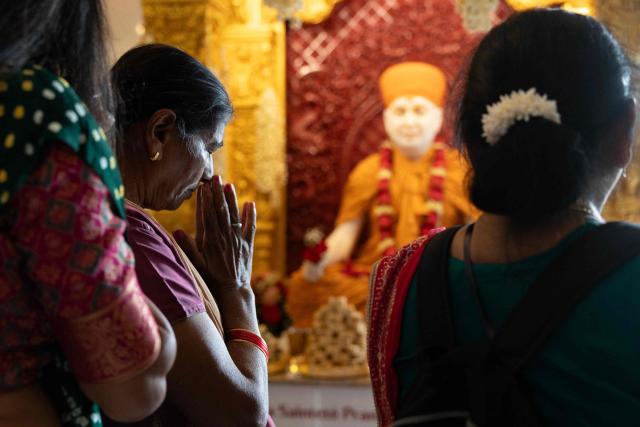 A Hindu devotee offers prayers after the consecration ceremony of the BAPS (Bochasanwasi Akshar Purushottam Swaminarayan Sanstha) Hindu temple in Bussy-Saint-Georges on September 6, 2026. On September 6, 2026, thousands of Hindus are celebrating the consecration of the first major temple built in France by the BAPS organization, which promotes it as 'an emblem of Indian culture and Hinduism.' Hailed as the largest Hindu temple built in continental Europe in a traditional style, the edifice stands in the new town of Bussy-Saint-Georges (Seine-et-Marne), 30 km east of the capital. (Photo by Kenzo TRIBOUILLARD / AFP)