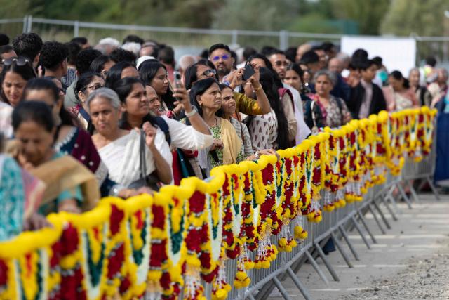 Hindu devotees queue to enter the newly consecrated BAPS (Bochasanwasi Akshar Purushottam Swaminarayan Sanstha) Hindu temple in Bussy-Saint-Georges on September 6, 2026. On September 6, 2026, thousands of Hindus are celebrating the consecration of the first major temple built in France by the BAPS organization, which promotes it as 'an emblem of Indian culture and Hinduism.' Hailed as the largest Hindu temple built in continental Europe in a traditional style, the edifice stands in the new town of Bussy-Saint-Georges (Seine-et-Marne), 30 km east of the capital. (Photo by Kenzo TRIBOUILLARD / AFP)