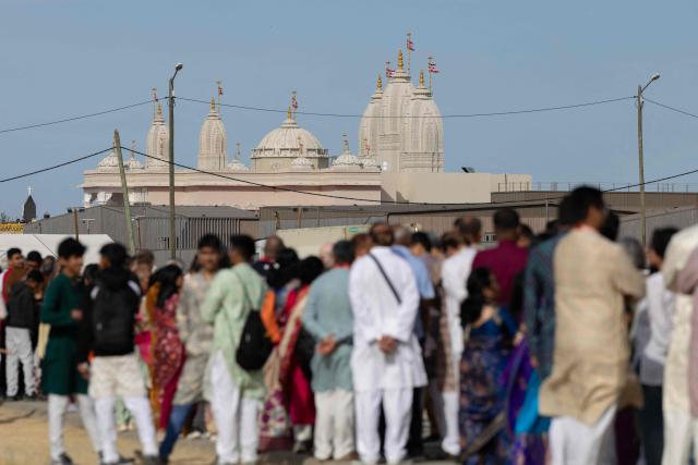 Hindu devotees queue to enter the newly consecrated BAPS (Bochasanwasi Akshar Purushottam Swaminarayan Sanstha) Hindu temple in Bussy-Saint-Georges on September 6, 2026. On September 6, 2026, thousands of Hindus are celebrating the consecration of the first major temple built in France by the BAPS organization, which promotes it as 'an emblem of Indian culture and Hinduism.' Hailed as the largest Hindu temple built in continental Europe in a traditional style, the edifice stands in the new town of Bussy-Saint-Georges (Seine-et-Marne), 30 km east of the capital. (Photo by Kenzo TRIBOUILLARD / AFP)