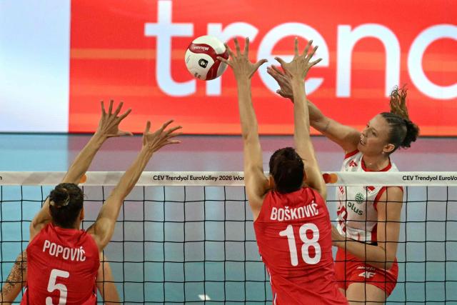 Poland's outside hitter #15 Martyna Czyrnianska (R) spikes the ball as Serbia's middle blocker #05 Mina Popovic (L) and Serbia's opposite #18 Tijana Boskovic jump to block it during the Women's European Volleyball Championship EuroVolley bronze medal match between Poland and Serbia at the Sinan Erdem Sports Hall in Istanbul on September 6, 2026. (Photo by Ozan KOSE / AFP)