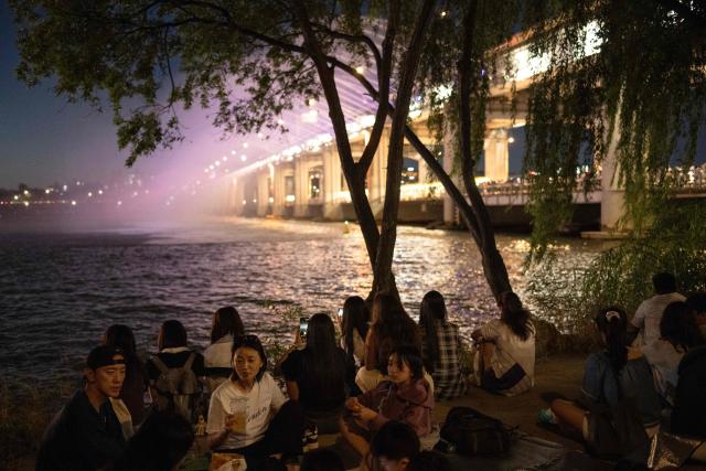 People gather to watch the Moonlight Rainbow Fountain on Banpo Bridge, over the Han River in Seoul on September 6, 2026. (Photo by Lillian SUWANRUMPHA / AFP)