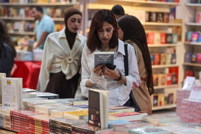 An Iraqi woman browses books at the Baghdad International Book Fair in Baghdad on September 6, 2026. (Photo by AHMAD AL-RUBAYE / AFP)