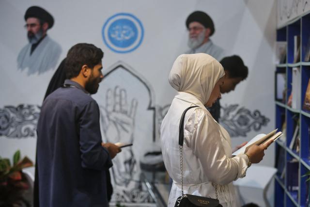 Portraits of Iran's supreme leader Mojtaba Khamenei (top-L) and late supreme leader Ayatollah Ali Khamenei (top-R) are displayed in the Iranian publishing pavilion at the Baghdad International Book Fair in Baghdad on September 6, 2026. (Photo by AHMAD AL-RUBAYE / AFP)