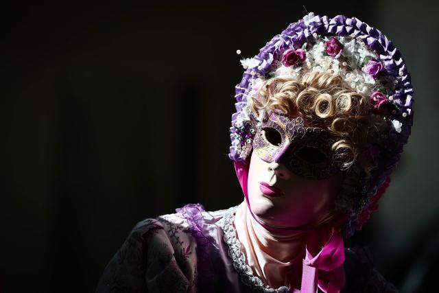 TOPSHOT - A person wearing a Venetian costume takes part in a parade through the town's streets during the 20th edition of Les Flaneries au Miroir, a Venetian-style costume gathering, in Martigues, south-eastern France, on September 6, 2026. (Photo by Thibaud MORITZ / AFP)