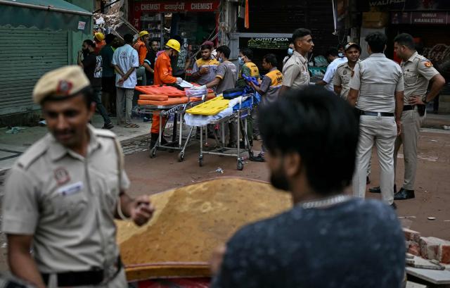 Paramedics prepare stretchers as rescue personnel conduct a search operation for survivors at the site of a building collapse in the Satya Niketan area in New Delhi on September 6, 2026. (Photo by Sajjad HUSSAIN / AFP)