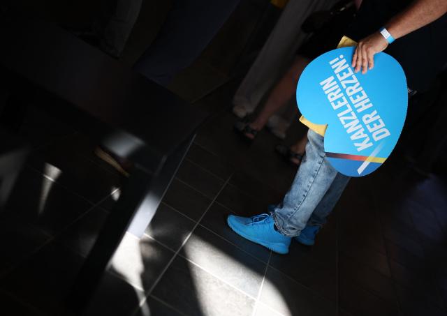 A supporter holds a heart-shaped sign reading "Chancellor of the Hearts" at the venue of the AfD's election party during Saxony-Anhalt's state elections in Magdeburg, eastern Germany on September 6, 2026. (Photo by Ronny HARTMANN / AFP)