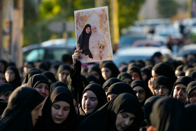 Mourners hold a picture of of Israa Bahjat (R), one of two women killed earlier in an Israeli strike on the village of Arabsalim, during her funeral in the southern Lebanese village of Jibshit on September 6, 2026. Lebanon’s Health Ministry said on September 6 that four people were killed in Israeli strikes in the south of the country, while Israel said it had carried out raids following a Hezbollah drone attack targeting its soldiers. (Photo by ammar ammar / AFP) / 