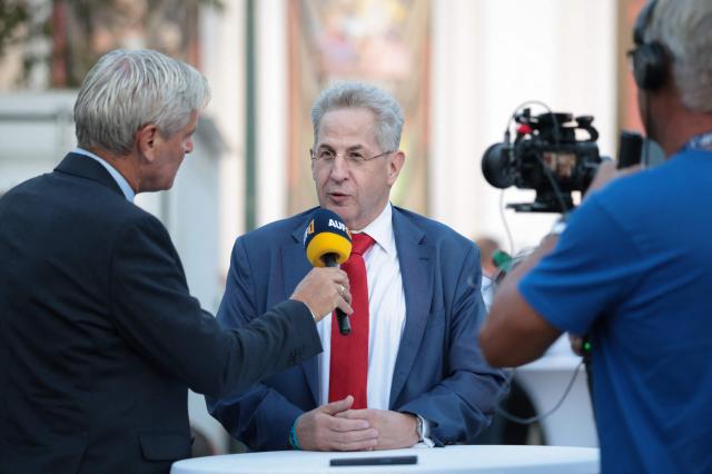 Hans-Georg Maassen (C), former president of the Federal Office for the Protection of the Constitution and former chairman of the right-wing conservative Werteunion party, gives an interview at the venue of the election party of far-right Alternative for Germany (AfD) party following Saxony-Anhalt's state elections in Magdeburg, eastern Germany on September 6, 2026. Germany's far-right AfD won key regional elections on September 6 by a landslide with at least 44 percent of the vote in the eastern state of Saxony-Anhalt, said exit polls by two public broadcasters. (Photo by Ronny HARTMANN / AFP)