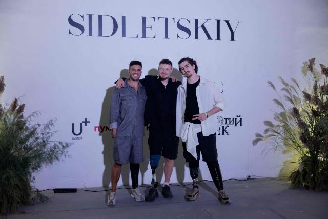 Ukrainian veterans pose for a photo after the Sidletskiy fashion show in collaboration with the U+System Military Prosthetics Center during Ukrainian Fashion Week in Kyiv on September 6, 2026, amid the Russian invasion of Ukraine. (Photo by Tetiana DZHAFAROVA / AFP)