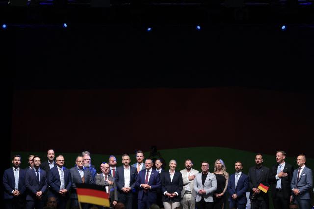 (C-LtoR) Ulrich Siegmund, far-right Alternative for Germany (AfD)'s main candidate in the Saxony-Anhalt state election, AfD co-leaders Tino Chrupalla and Alice Weidel and other party members sing the national anthem at the AfD's election party following Saxony-Anhalt's state elections in Magdeburg, eastern Germany on September 6, 2026. Germany's far-right AfD won a landslide victory in a key regional election on September 6 in the ex-communist east, according to exit polls, but it remain unclear whether it can win an absolute majority to govern. (Photo by Ronny HARTMANN / AFP)