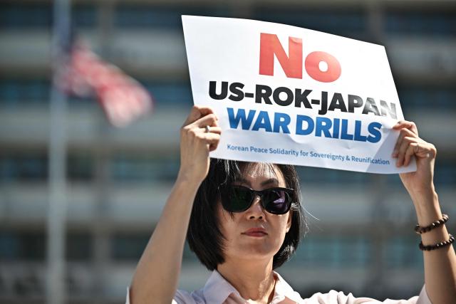 A member of the Korean Peace Solidarity for Sovereignty and Reunification protests against the South Korea, US and Japan trilateral joint military exercise “Freedom Edge”, in front of the US Embassy in Seoul on September 7, 2026. (Photo by Lillian SUWANRUMPHA / AFP)
