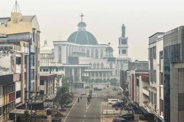 This aerial picture shows haze from land and forest fires blanketing the Cathedral Church in the city of Pontianak, West Kalimantan, on September 7, 2026. (Photo by BAY ISMOYO / AFP)