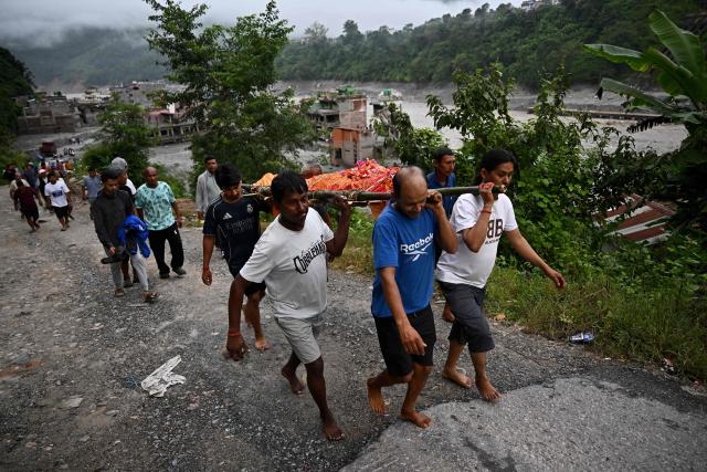Mourners carry the body of a flash flood victim during a funeral at Trishuli in Nepal's Nuwakot district on September 7, 2026. Nepali rescuers faced challenging conditions on September 6, as search operations after catastrophic floods entered a 12th day. The glacial and mountain collapse on the China-Nepal border killed at least 1,385 people and left more than 5,500 missing across the two countries. (Photo by Pedro PARDO / AFP)