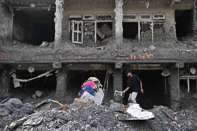 A man tries to recover his belongings in the aftermath of flash floods at Trishuli in Nepal's Nuwakot district on September 7, 2026. The August 26 glacial and mountain collapse on the China-Nepal border killed at least 1,385 people, with more than 5,500 missing across the two countries. (Photo by Pedro PARDO / AFP)