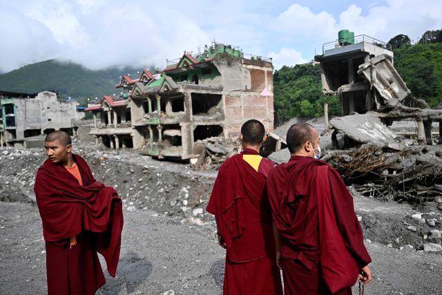 TOPSHOT - Buddhist monks look at the remains before a ceremony for flash flood victims at Trishuli, in Nepal's Nuwakot district, on September 7, 2026. The August 26 glacial and mountain collapse on the China-Nepal border killed at least 1,385 people, with more than 5,500 missing across the two countries. (Photo by Pedro PARDO / AFP)