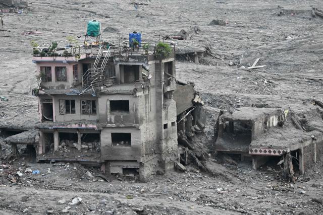 A damaged building lies inundated in sludge in the aftermath of flash floods at Trishuli in Nepal's Nuwakot district on September 7, 2026. The August 26 glacial and mountain collapse on the China-Nepal border killed at least 1,398 people, with more than 5,500 missing, including around 800 foreigners. (Photo by Pedro PARDO / AFP)