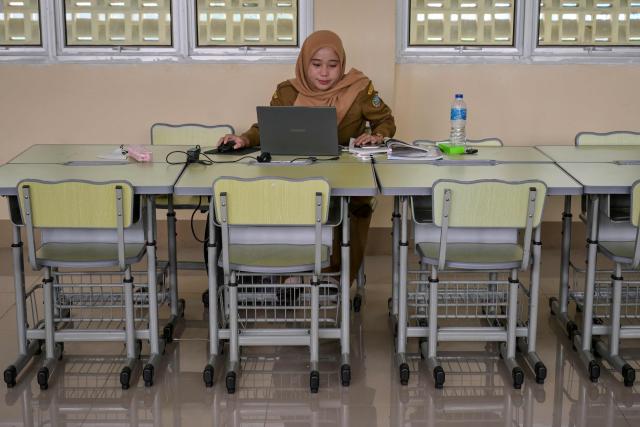 A junior high school teacher conducts an online lesson in an empty classroom after local authorities mandated remote learning due to haze from land and forest fires in Pontianak, West Kalimantan, on September 7, 2026. Toxic haze has shrouded parts of Indonesia and Malaysia for weeks as Jakarta struggles to contain fires that have scorched large tracts of Borneo and Sumatra, with the smoke drifting into neighbouring Malaysia, Singapore, and Brunei. (Photo by BAY ISMOYO / AFP)