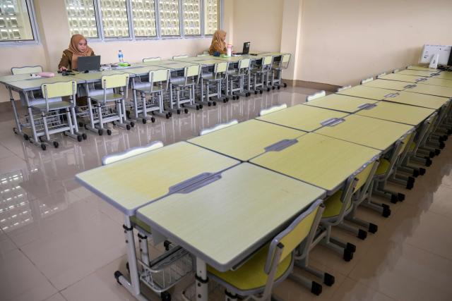 Junior high school teachers conduct online lessons in an empty classroom after local authorities mandated remote learning due to haze from land and forest fires in Pontianak, West Kalimantan, on September 7, 2026. Toxic haze has shrouded parts of Indonesia and Malaysia for weeks as Jakarta struggles to contain fires that have scorched large tracts of Borneo and Sumatra, with the smoke drifting into neighbouring Malaysia, Singapore, and Brunei. (Photo by BAY ISMOYO / AFP)