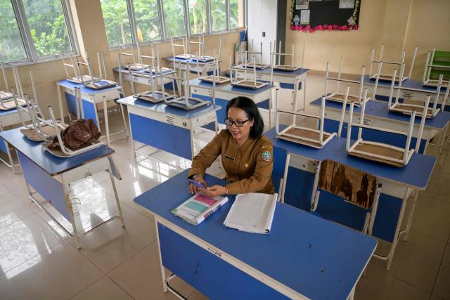 A junior high school teacher conducts an online lesson in an empty classroom after local authorities mandated remote learning due to haze from land and forest fires in Pontianak, West Kalimantan, on September 7, 2026. Toxic haze has shrouded parts of Indonesia and Malaysia for weeks as Jakarta struggles to contain fires that have scorched large tracts of Borneo and Sumatra, with the smoke drifting into neighbouring Malaysia, Singapore, and Brunei. (Photo by BAY ISMOYO / AFP)