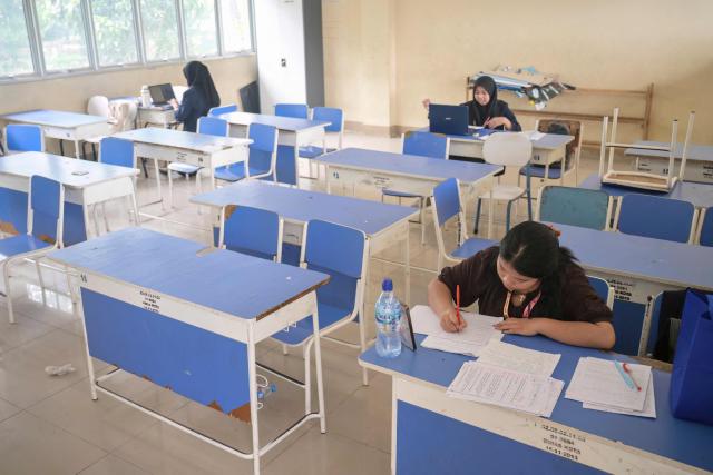 Junior high school teachers conduct online lessons in an empty classroom after local authorities mandated remote learning due to haze from land and forest fires in Pontianak, West Kalimantan, on September 7, 2026. Toxic haze has shrouded parts of Indonesia and Malaysia for weeks as Jakarta struggles to contain fires that have scorched large tracts of Borneo and Sumatra, with the smoke drifting into neighbouring Malaysia, Singapore, and Brunei. (Photo by BAY ISMOYO / AFP)